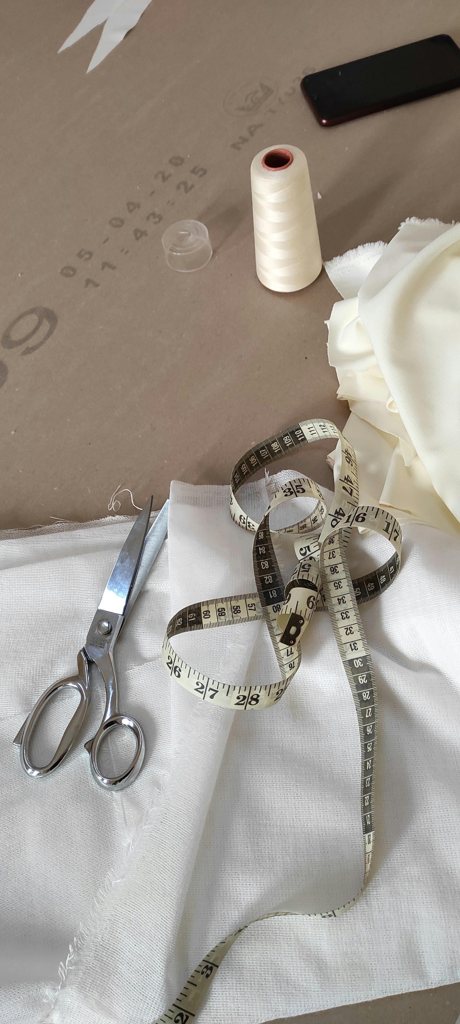 Tailoring shears and a tape measure on white cloth